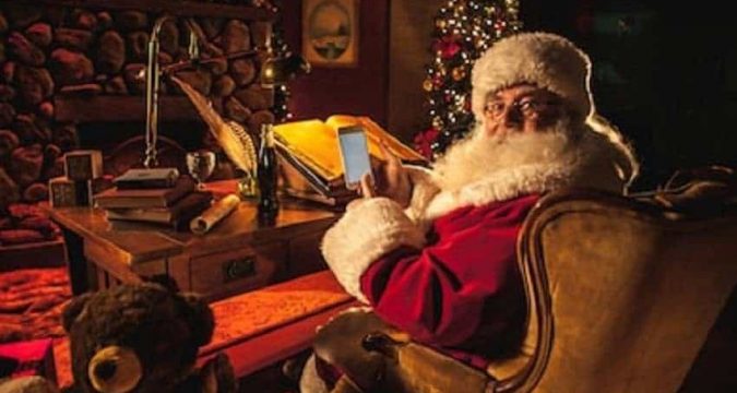 santa claus using a smartphone to gamble at his desk